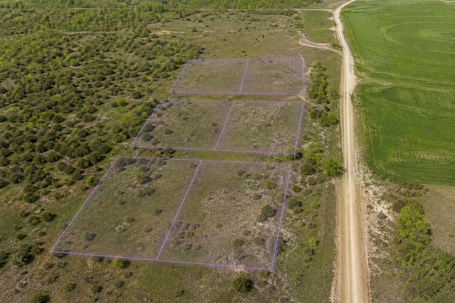 Aerial undeveloped land with proposed building footprint overlays